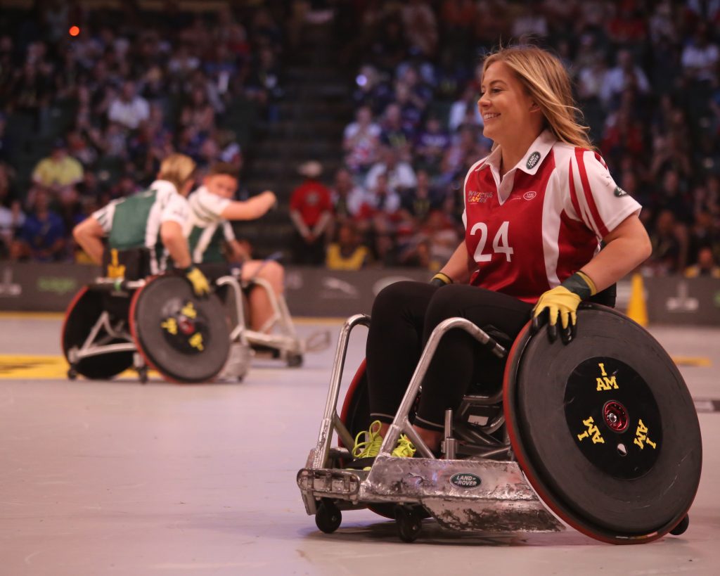 Dame i rullestol spiller basketball med funksjonsnedsettelse